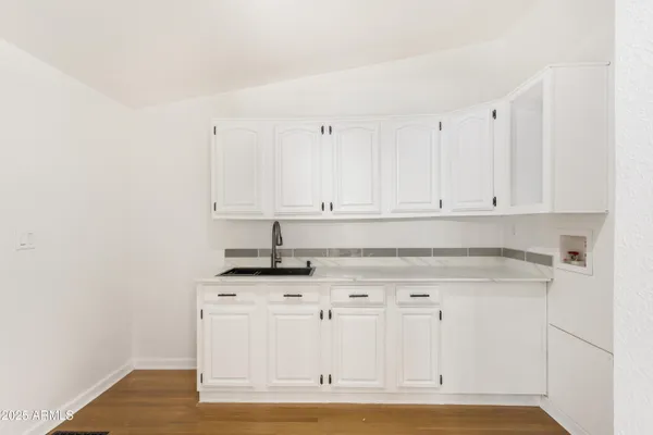 a kitchen with granite countertop white cabinets and white appliances