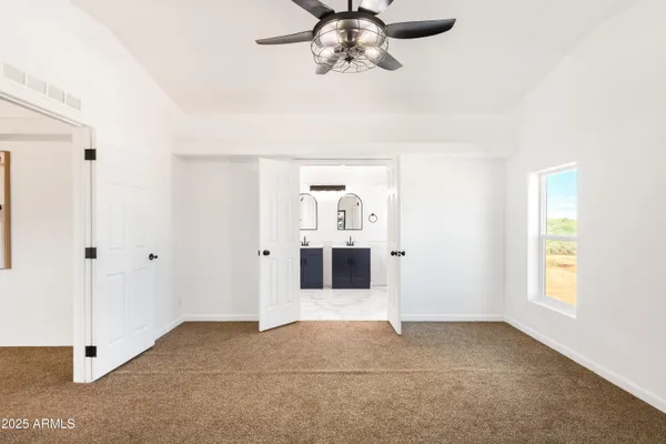 a view of a big room with windows and chandelier fan