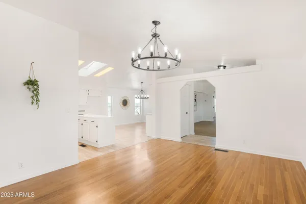 a view of empty room with wooden floor and window