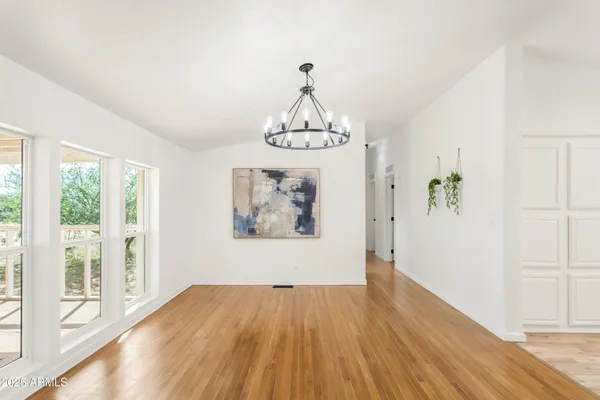 a view of wooden floor chandelier and closet in a room