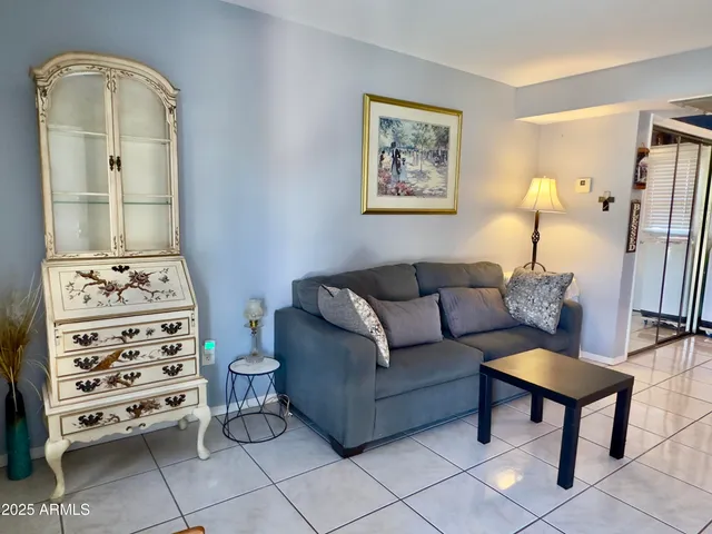 a living room with furniture and a painting on the wall