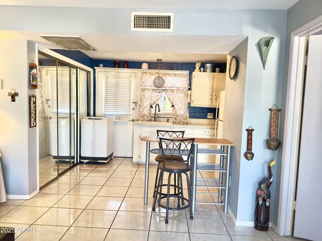 a room with stainless steel appliances kitchen island granite countertop furniture and a refrigerator
