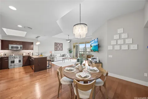 a view of a dining room with furniture a chandelier and wooden floor