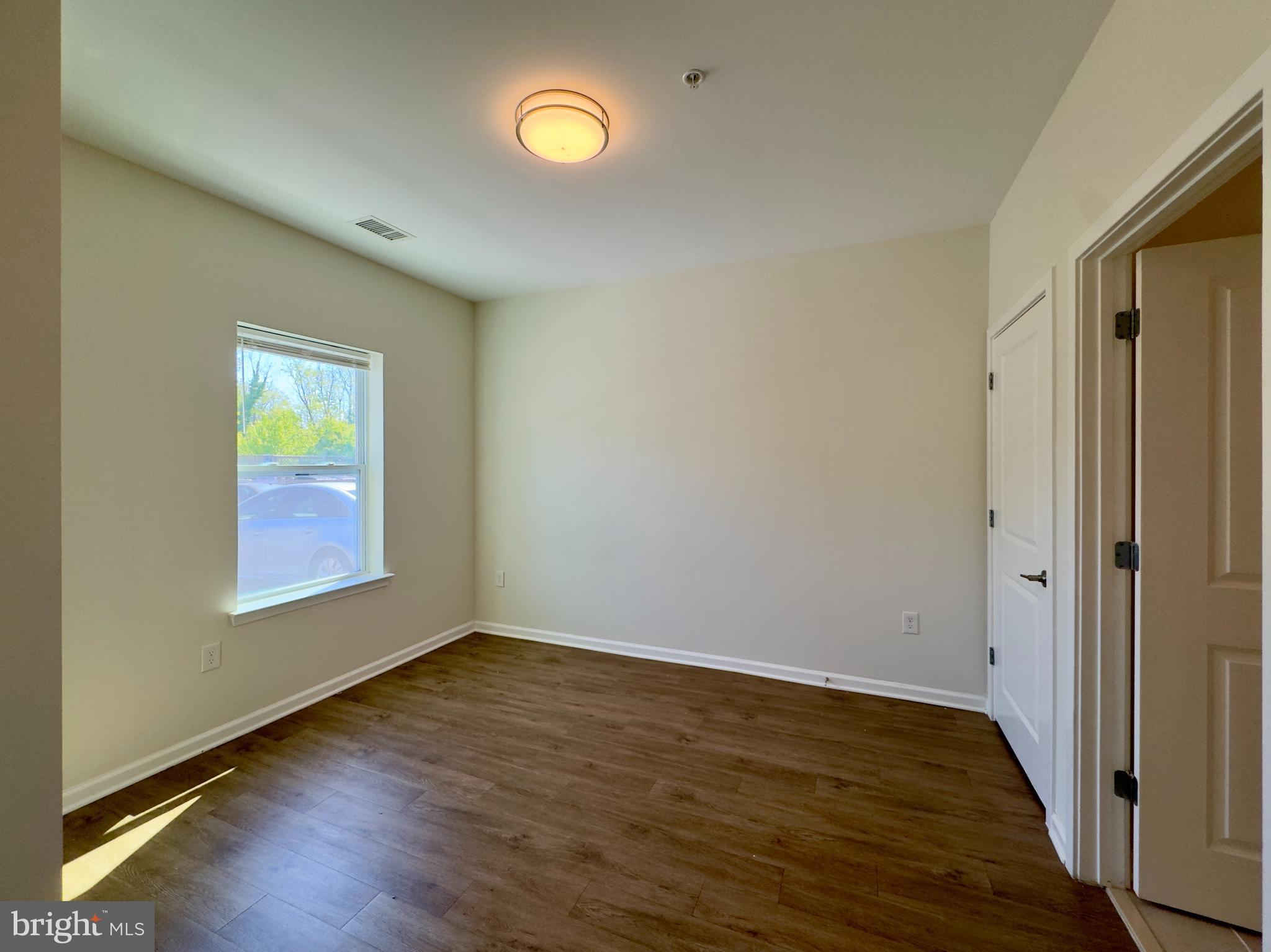 5608 Bucknell Road, Unit A Baltimore, MD 21206 - Photo 11 of 13 an empty room with wooden floor and windows