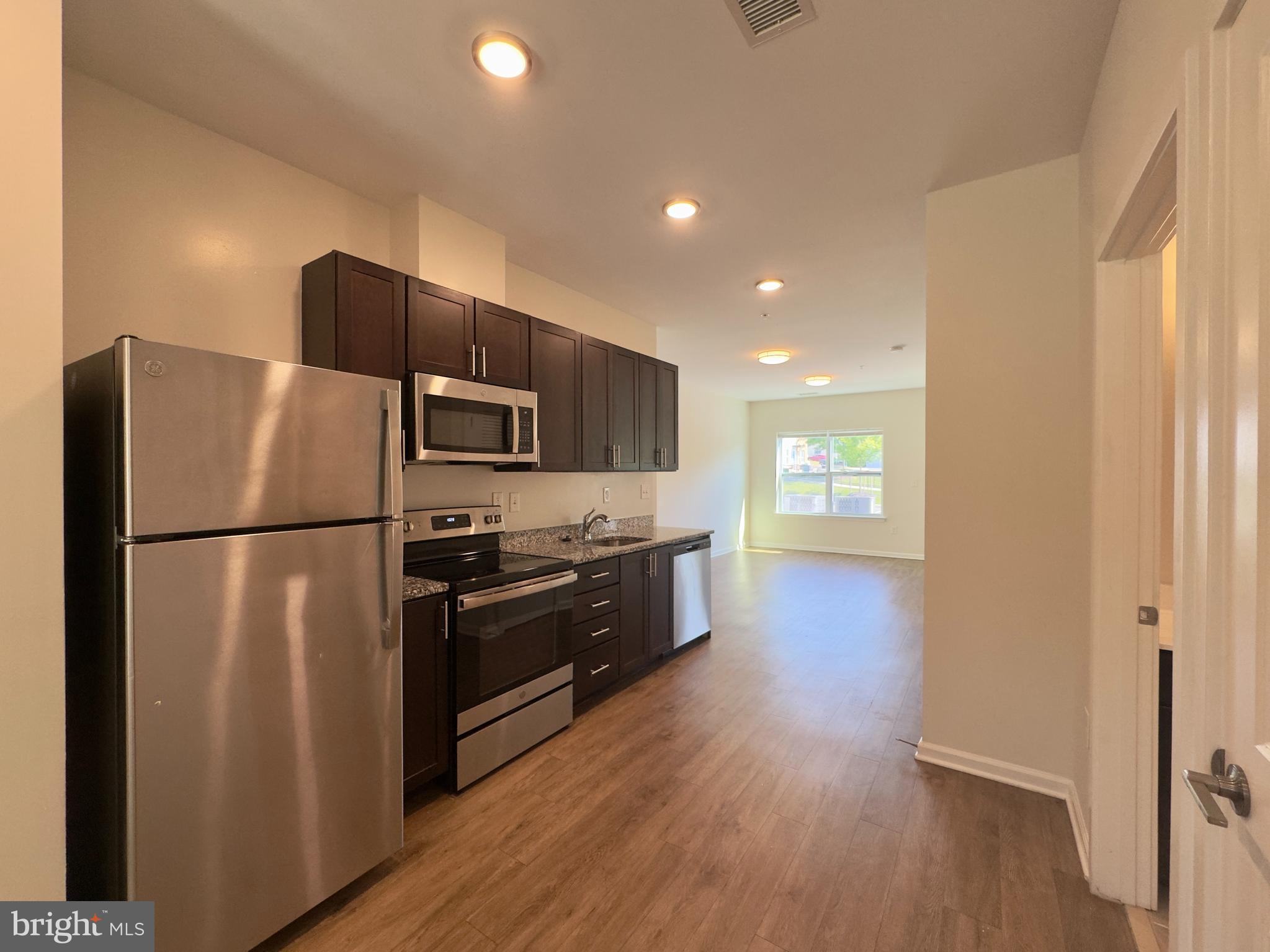 5608 Bucknell Road, Unit A Baltimore, MD 21206 - Photo 4 of 13 a kitchen with stainless steel appliances a refrigerator and a stove top oven