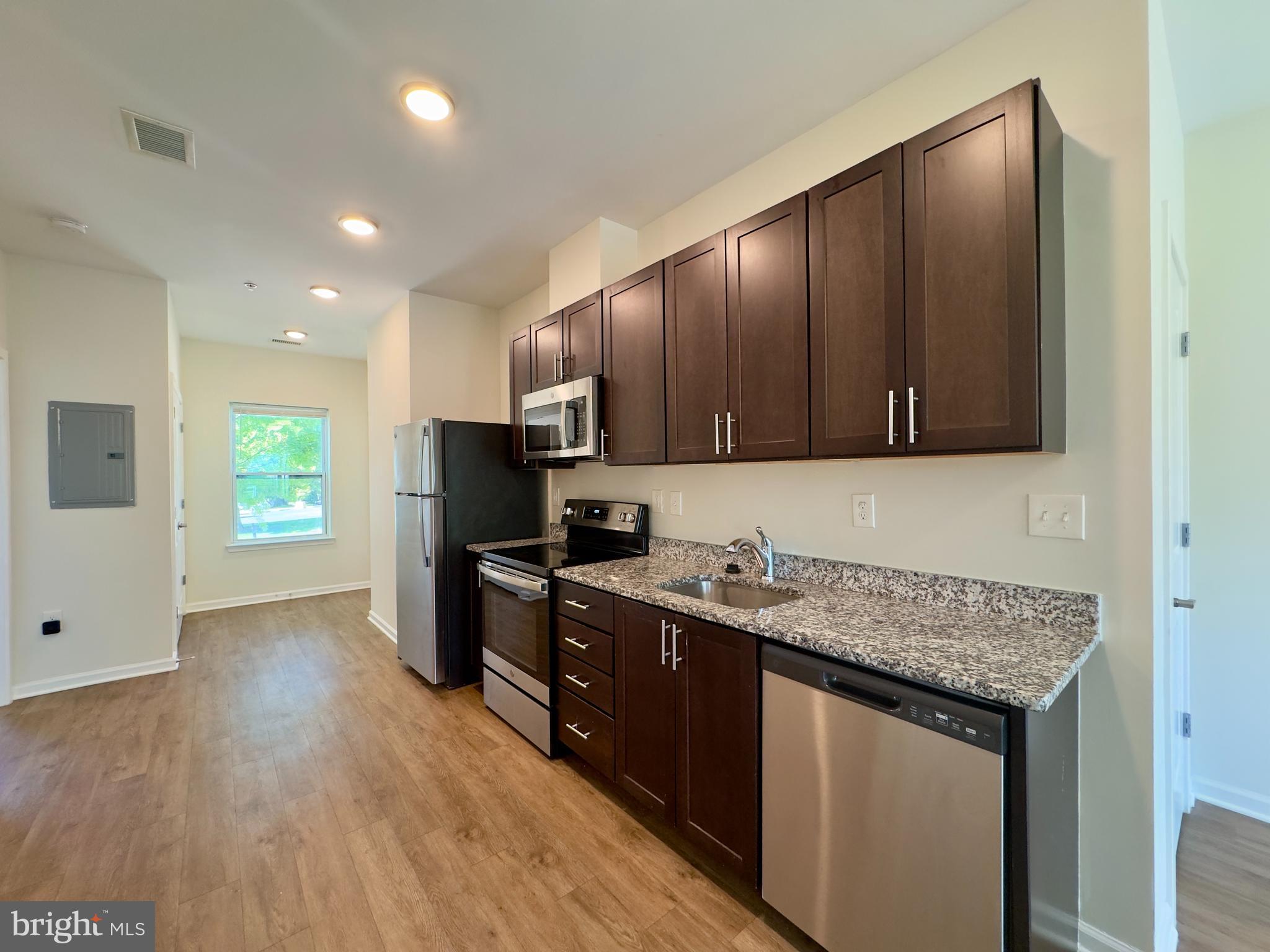 5608 Bucknell Road, Unit A Baltimore, MD 21206 - Photo 8 of 13 a kitchen with stainless steel appliances granite countertop a sink stove and refrigerator