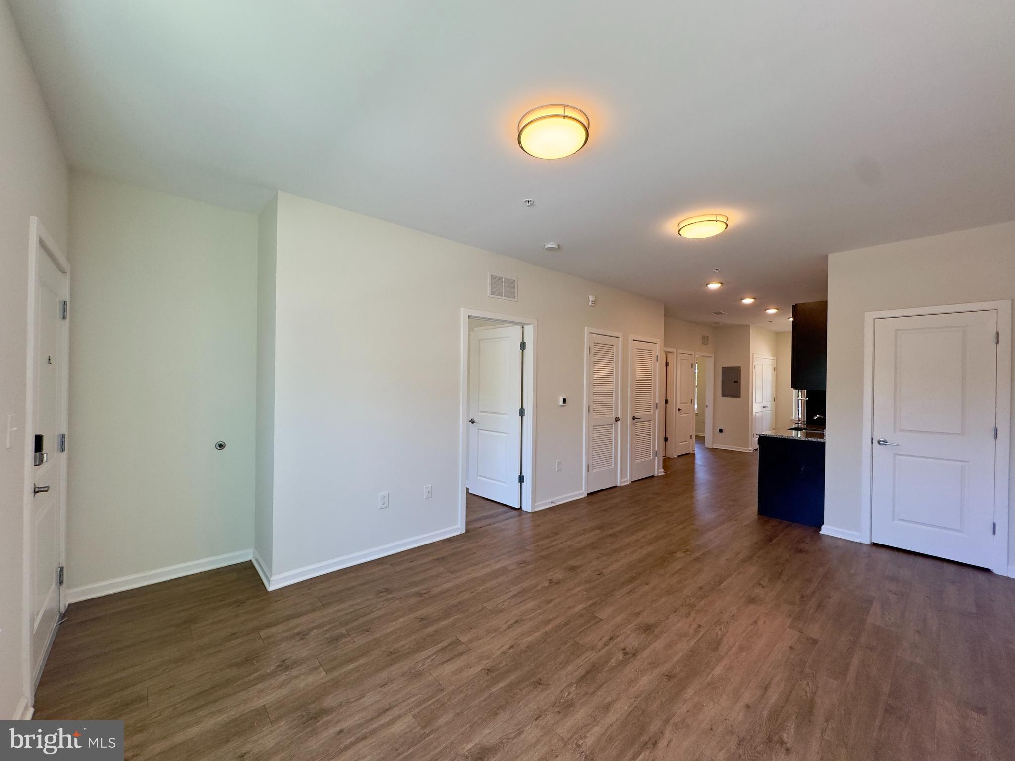 5608 Bucknell Road, Unit A Baltimore, MD 21206 - Photo 10 of 13 an empty room with wooden floor and windows