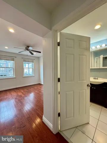a view of a hallway with wooden floor and a living room