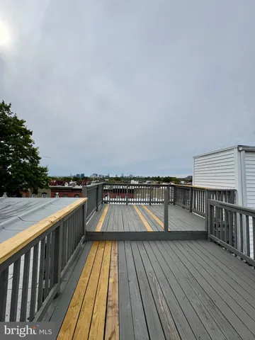 a view of balcony with wooden floor and seating space