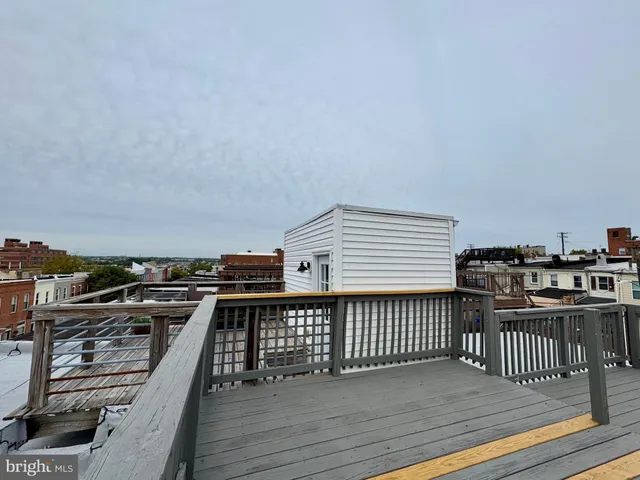 a view of a roof deck with wooden floor and fence