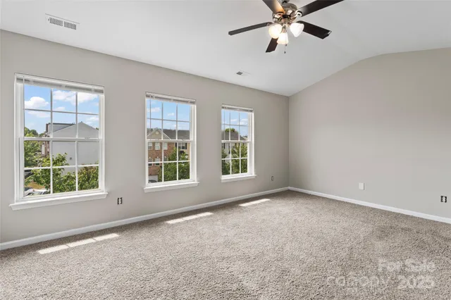 a view of an empty room with a window and a ceiling fan