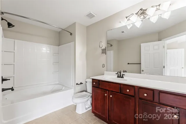 a bathroom with a sink double vanity bathtub and a toilet