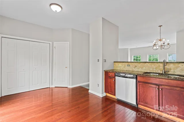 a kitchen with stainless steel appliances granite countertop a sink cabinets and wooden floor