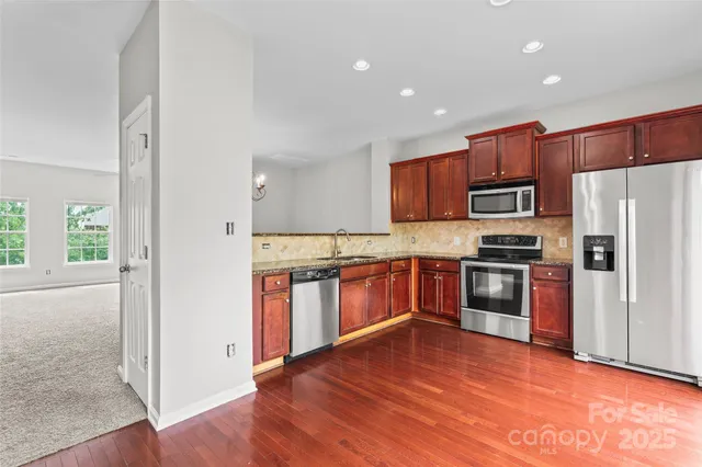 a kitchen with stainless steel appliances a refrigerator and a stove top oven