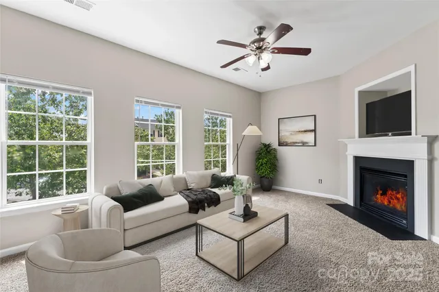 a living room with furniture a flat screen tv and a fireplace
