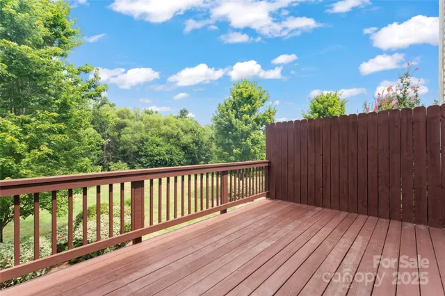 a balcony with wooden floor and yard in the back