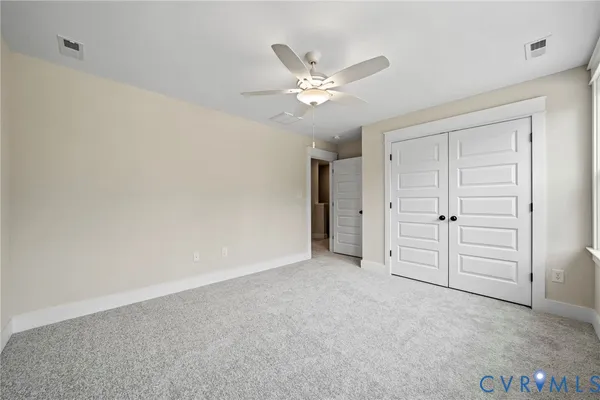 an empty room with closet and fan