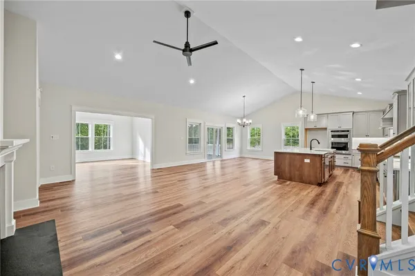 a large kitchen with stainless steel appliances kitchen island a large counter tops and a wooden floor