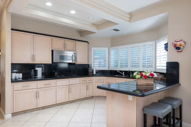 a kitchen with granite countertop a sink stainless steel appliances and cabinets