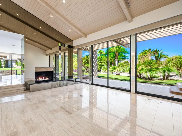 a view of an empty room with a fireplace and a floor to ceiling window