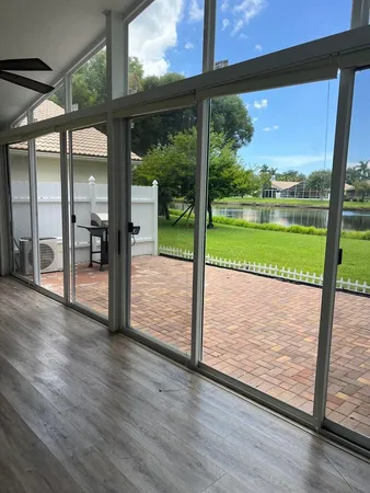 a view of a room with wooden floor and a floor to ceiling window