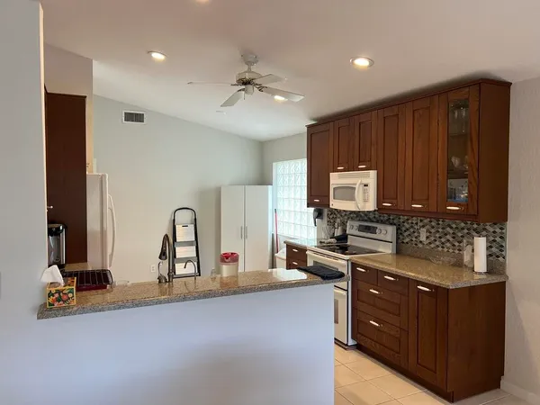 a kitchen with stainless steel appliances granite countertop a stove a sink and a refrigerator