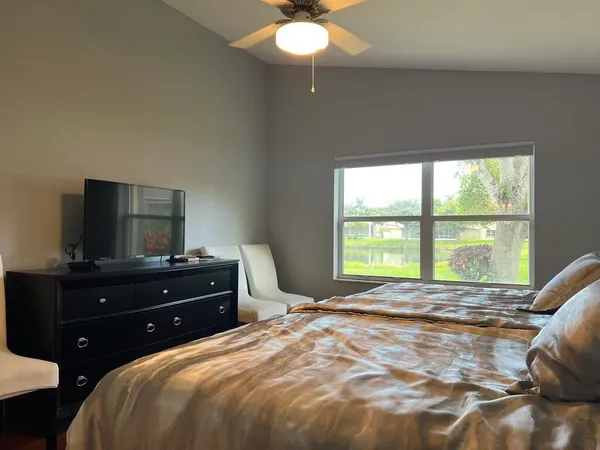 a bedroom with a bed and a flat tv screen on dresser