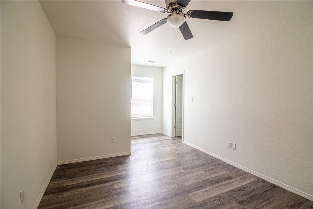 803 South Rupple Road, Unit 1 Fayetteville, AR 72704 - Photo 14 of 22 Interior room featuring wood-finish flooring, white painted walls, and a ceiling fan with light fixture