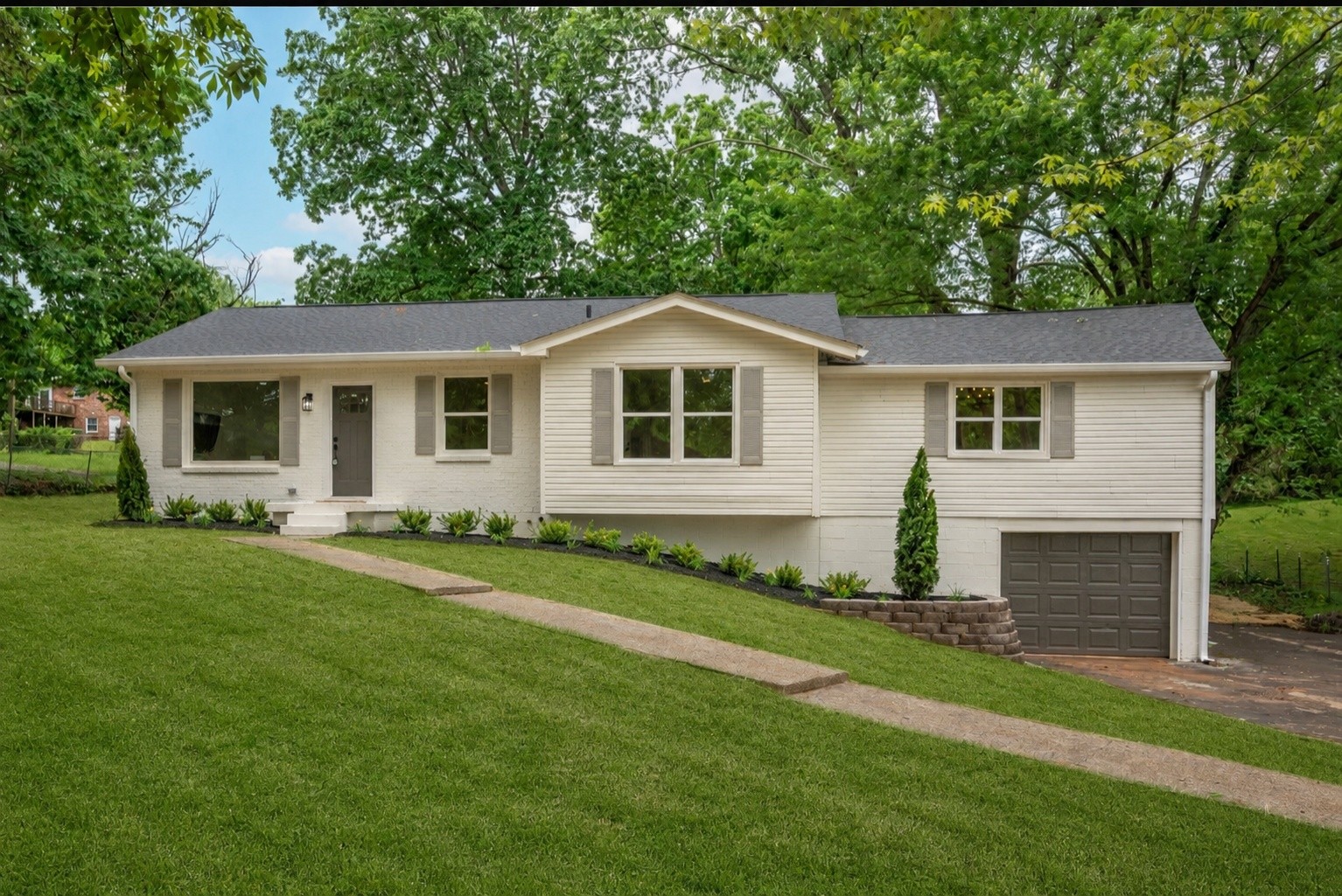 a front view of a house with a garden