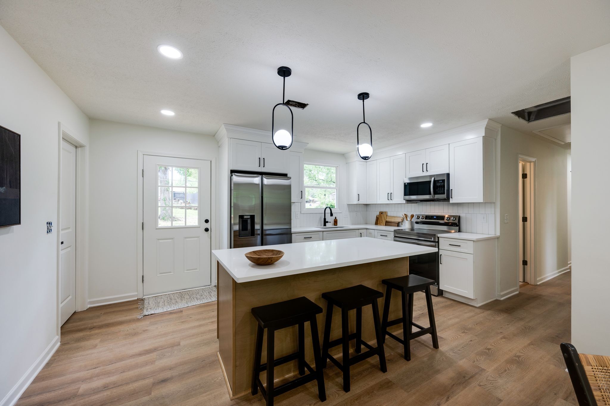 312 Bluebird Lane Dickson, TN 37055 - Photo 6 of 25 a kitchen with stainless steel appliances kitchen island granite countertop a table chairs refrigerator and microwave