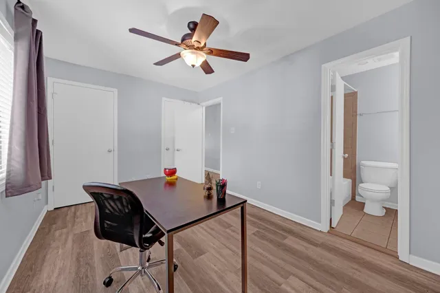 a workspace with wooden floor and a chandelier fan