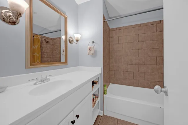 a bathroom with a tub a sink and mirror