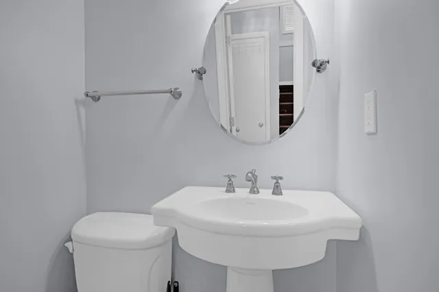 a bathroom with a sink a mirror and toilet