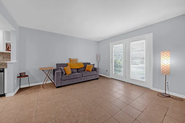 a living room with furniture a air conditioner vent and a window