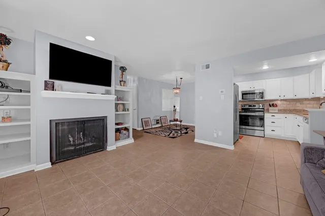 a view of a livingroom with a fireplace a flat screen tv and staircase