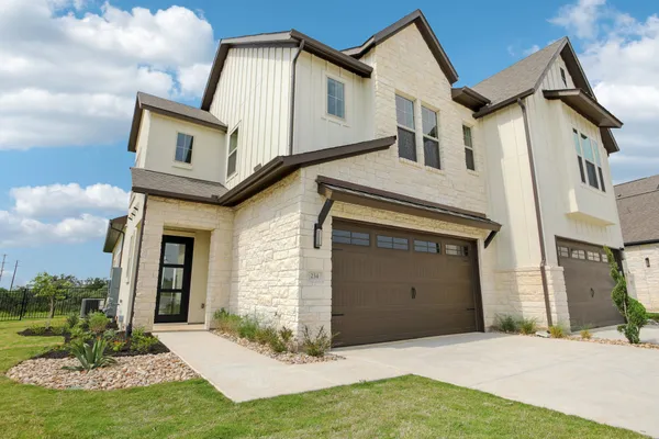 a front view of a house with a yard garage and outdoor seating