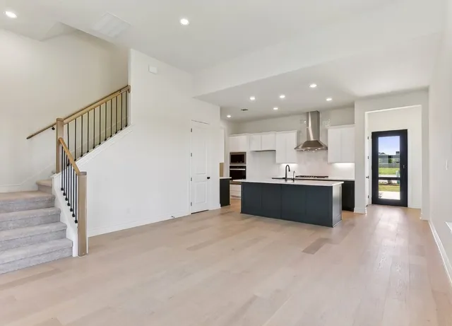 a view of kitchen with kitchen island microwave and cabinets
