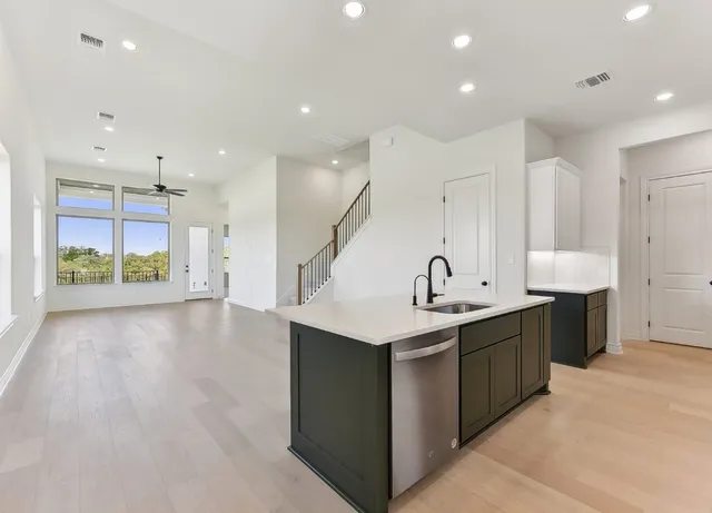 a kitchen with stainless steel appliances granite countertop a sink and a stove top oven