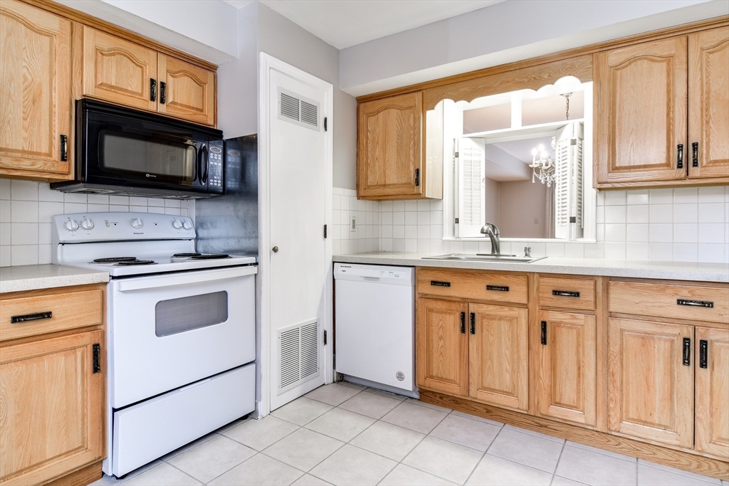1907 Windsor Drive, Unit 1907 Framingham, MA 01701 - Photo 6 of 22 a kitchen with granite countertop white cabinets stainless steel appliances and a sink