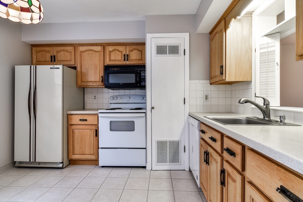 1907 Windsor Drive, Unit 1907 Framingham, MA 01701 - Photo 7 of 22 a kitchen with a stove sink and a refrigerator