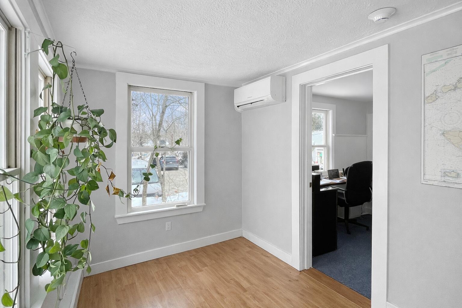 378 State Road Vineyard Haven, MA 02568 - Photo 7 of 23 a view of a hallway with wooden floor and a livingroom with furniture