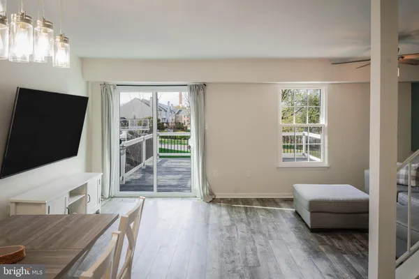 a living room with furniture a chandelier and wooden floor