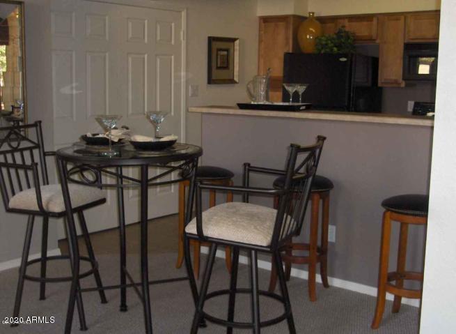 8787 East Mountain View Road, Unit 1014 Scottsdale, AZ 85258 - Photo 5 of 27 a view of a dining room with furniture and wooden floor