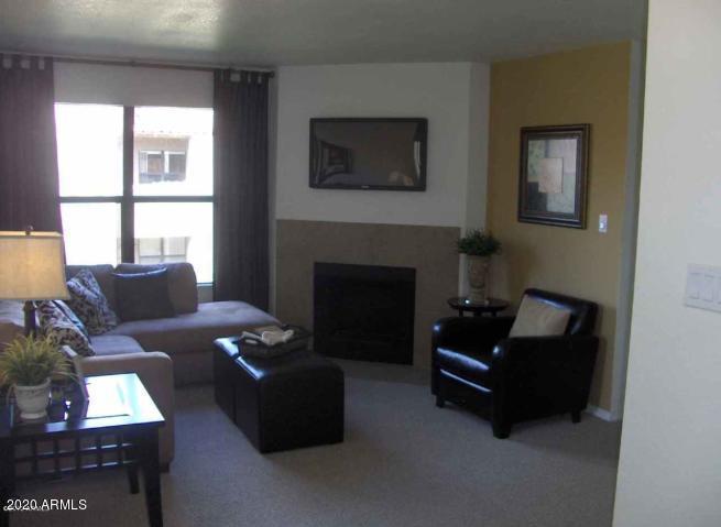 8787 East Mountain View Road, Unit 1014 Scottsdale, AZ 85258 - Photo 8 of 27 a living room with furniture and a fireplace