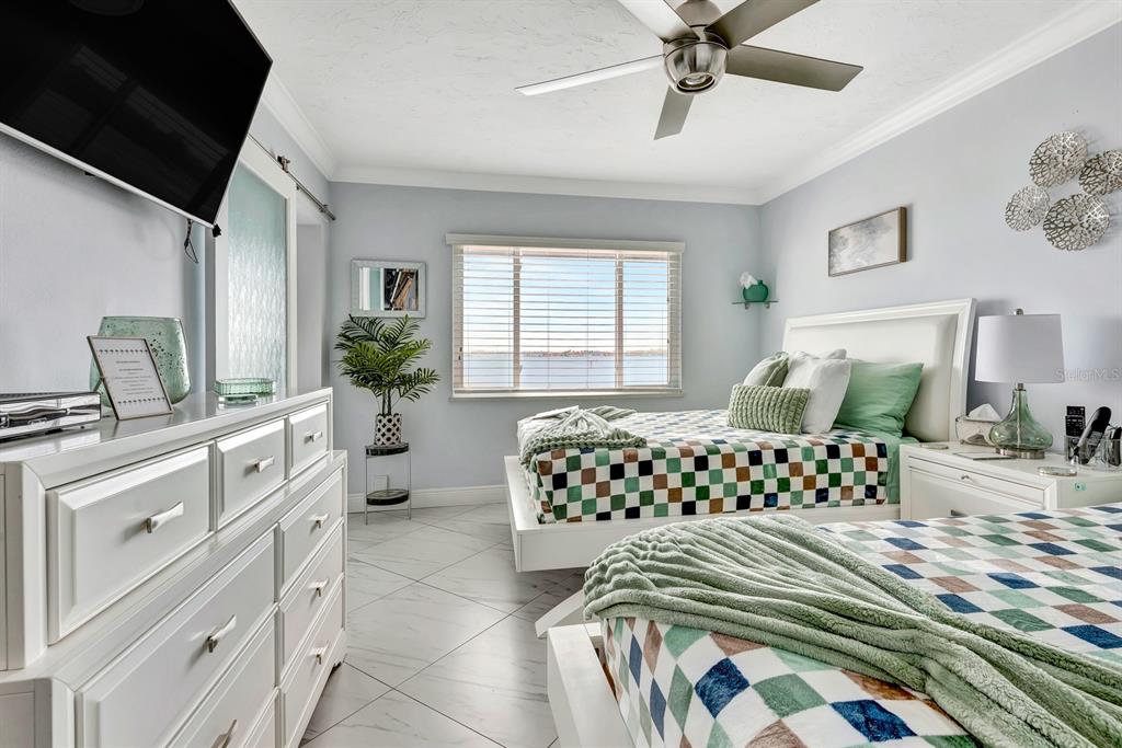 1602 Stickney Point Road, Unit 404 Sarasota, FL 34231 - Photo 23 of 38 a bedroom with a bed and a chandelier