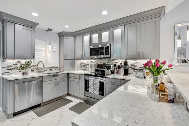 a kitchen with sink a microwave and cabinets