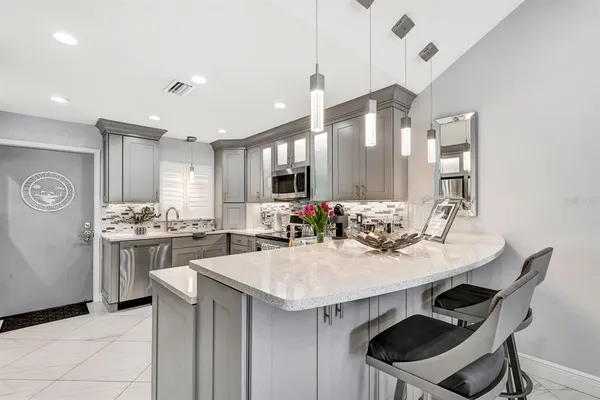 a kitchen with kitchen island a stove a table and chairs in it
