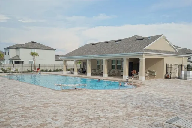 a front view of a house with swimming pool and porch