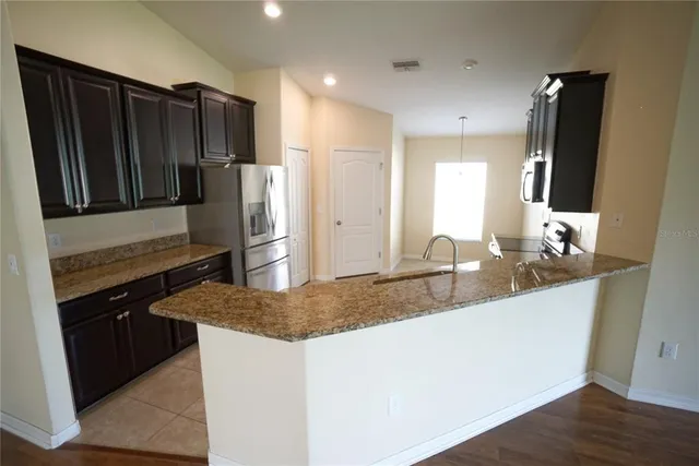 a kitchen with stainless steel appliances granite countertop a refrigerator and a sink