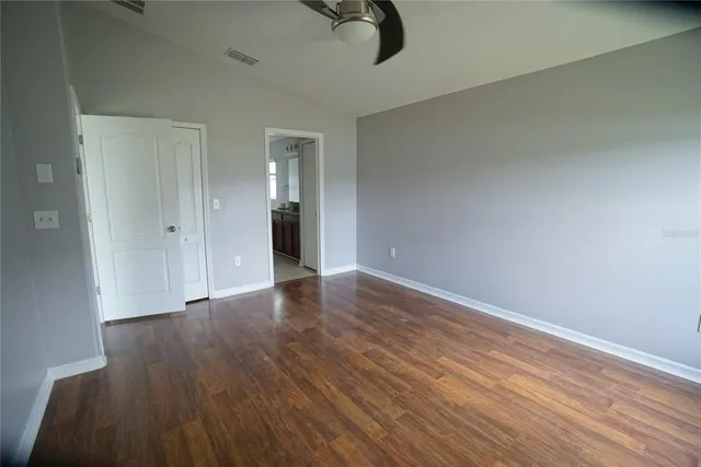 a view of an empty room with wooden floor